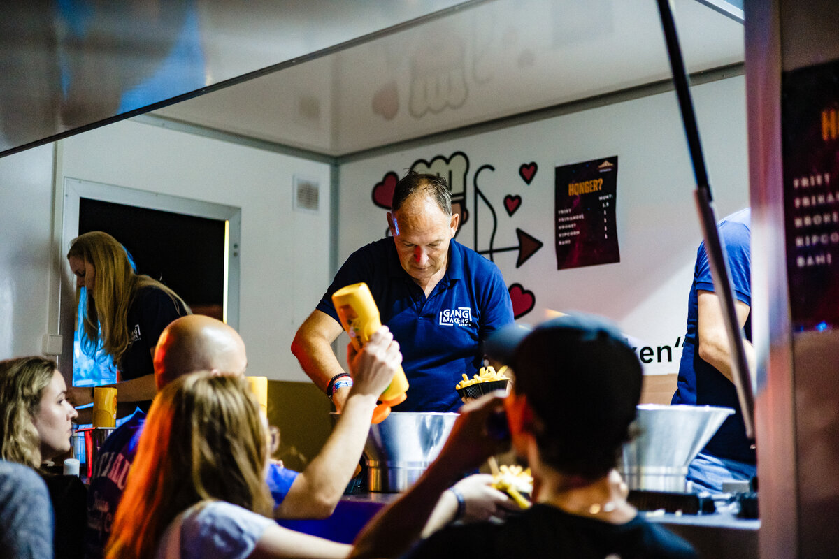 Vrijwilliger van Pleinfeest Ottersum serveert friet aan bezoekers